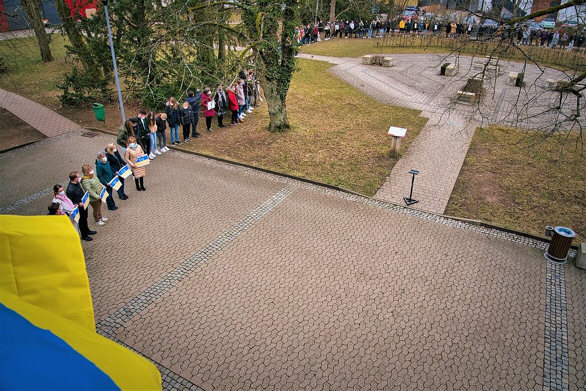Eine Menschenkette und eine Ukraine-Flagge