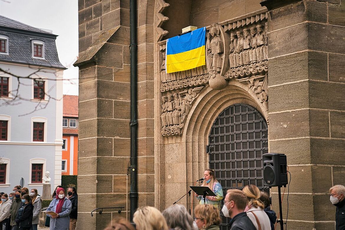 Eine Kirche von außen mit der Ukraine Flagge daran hängend