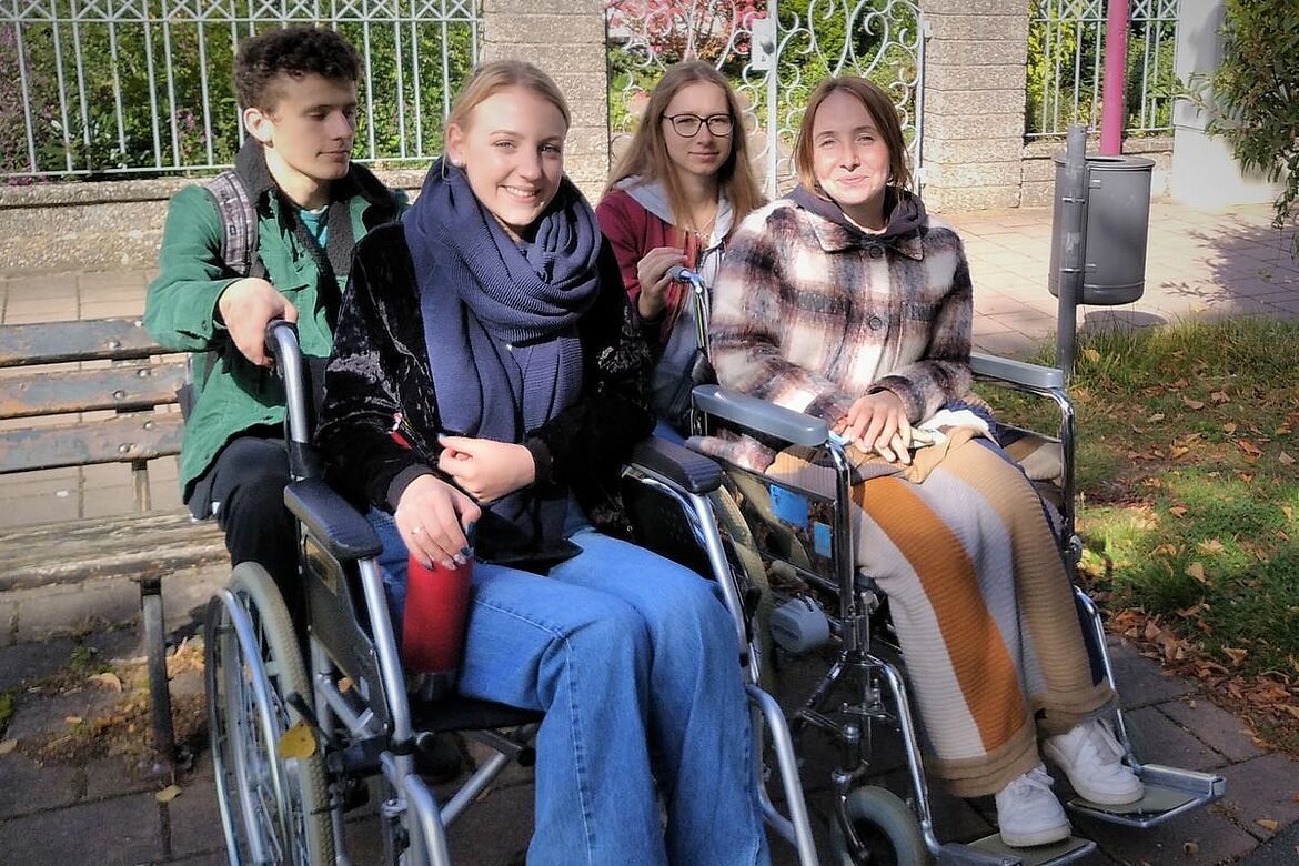 Mehrere jüngere Menschen in Rollstühlen