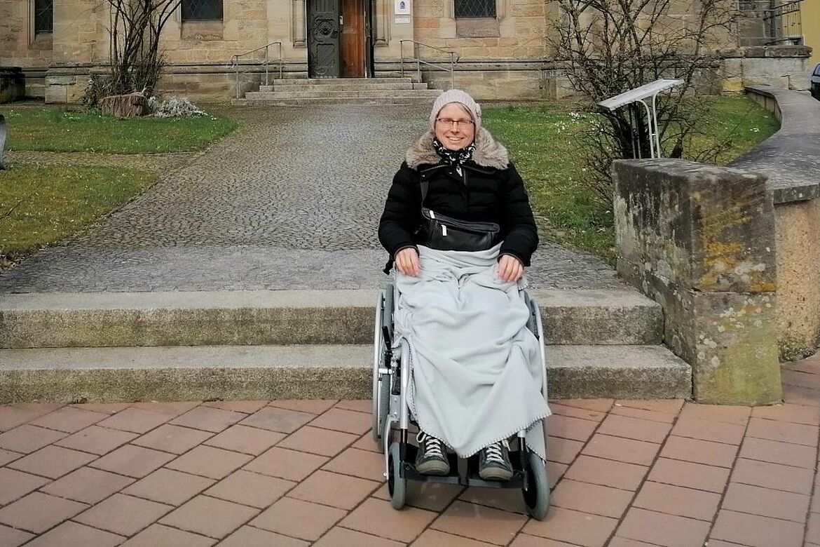 Ein Bild einer älteren Frau im Rollstuhl sitzend
